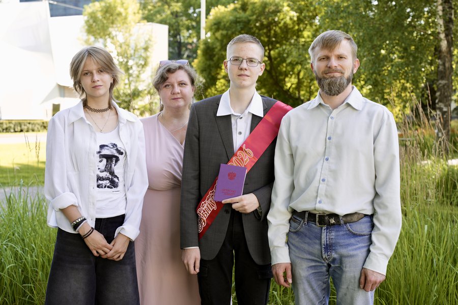 Выпускник в ленте с семьёй и аттестатом